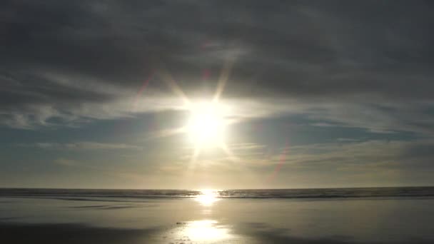 Soleil brillant vers le bas sur la plage de sable dans le nord-ouest du Pacifique, Oregon près du coucher du soleil .