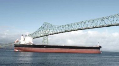 Büyük bir yük gemisi Astoria, Oregon 'da köprü altından limana doğru ilerliyor..
