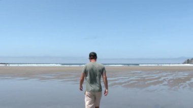 Model serbest bırakılan kişi, Oregon Sahili 'nde, Oswald West State Parkı' nda kumlu sahilde okyanusa doğru yürüyor..