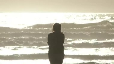 Güneşli bir günde Pasifik Okyanusu 'nda tek başına duran bir kadın..