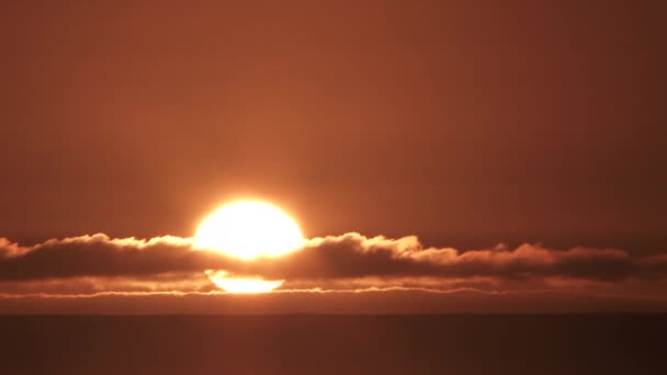 大きな明るい太陽の時間の経過は 明確な空に落ち 海の地平線の下に落ちる前に 最終的な雲の層を通して — ストック動画