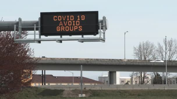Дорожном Знаке Написано Covid Avoid Groups Над Проезжей Частью Автомобилями — стоковое видео
