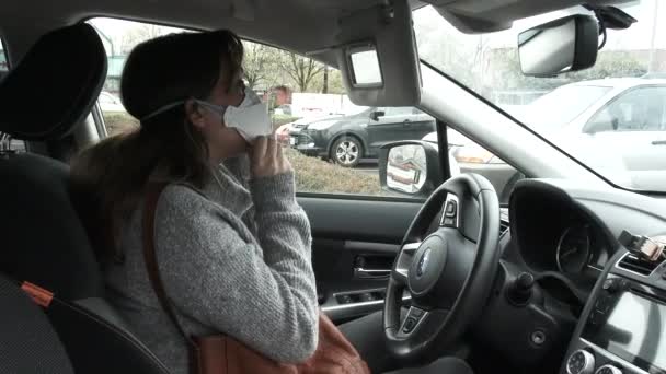 車の中で女性は必需品のために外出する前にマスクをマスクに置きます — ストック動画