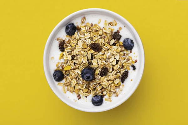 Müsli Mit Joghurt Einer Schüssel Auf Gelbem Hintergrund — Stockfoto