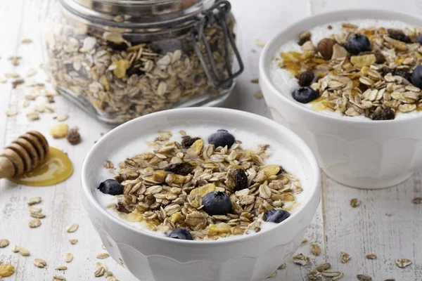 Müsli Mit Joghurt Einer Schüssel Auf Weißem Holzgrund — Stockfoto