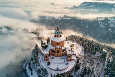 Aerial view of San Luca Sanctuary covered with snow in winter time with blue sky. Bologna, Italy. clipart