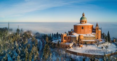Aerial view of San Luca Sanctuary covered with snow in winter time with blue sky. Bologna, Italy. clipart