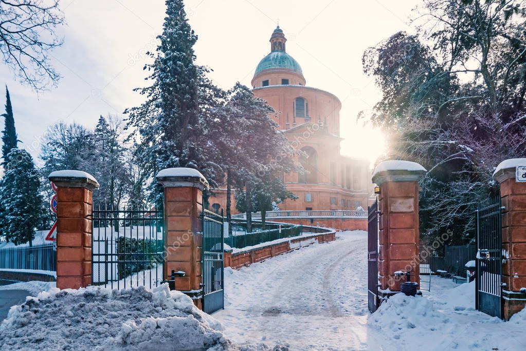 San Luca Sanctuary covered with snow in winter time with blue sky. Bologna, Italy.
