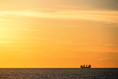 Kargo gemisi silouette gün batımında denize.