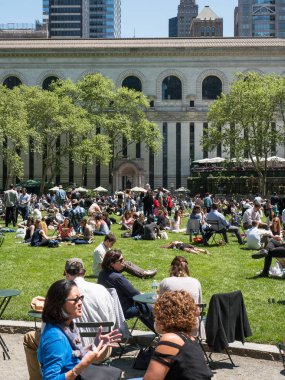 New York City - 14 Mayıs 2015: Turist ve New Yorklu güneşli bir günde Bryant Park'ta öğle yemeği zevk. Bryant Park Manhattan'da bulunan bir 9.603 dönümlük (38,860 m2) özel olarak yönetilen kamu parkıdır. 