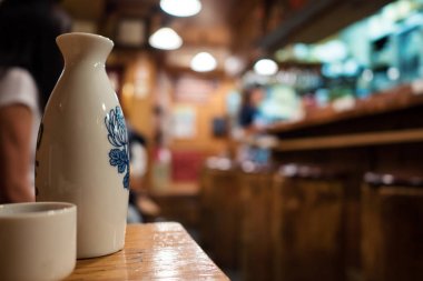 Sake şişe ve Restoran arka planda yak²n fincanla.