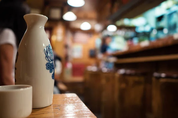 Sake Flaskan Och Cup Med Restaurang Fokus Bakgrunden — Stockfoto