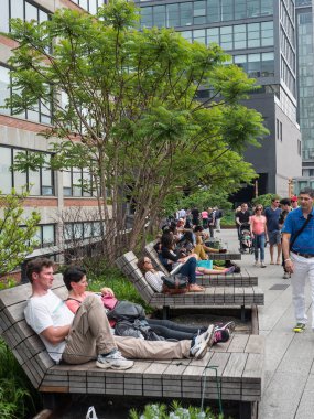 NEW YORK CITY - MAY 16, 2015: People walking on the High Line Park. The High Line is a park built on an historic freight rail line elevated above the streets in the West Side. clipart