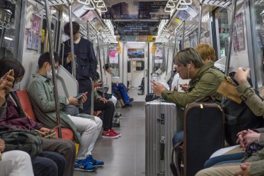 Tokyo, Japonya - Mart, 2017 yaklaşık: metro vagonu binme süre içinde akıllı telefonlar kullanan kişiler. Modern toplumda iletişim eksikliği kavramı. 