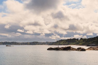 Bulutlu bir günde doğal görünümü ile yalnız balıkçı Beach. Brittany, Fransa.