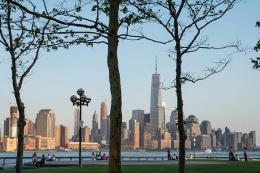 New York City - 12 Mayıs 2015: New York'un Manhattan siluetinin Hudson Nehri ve New Jersey iskele Parkı'ndan gündüz görüntülenen çalışan insanlar üzerinde. 