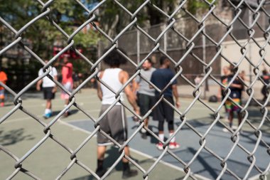 Kafes detay ve oyuncular oyuncular, bir 20-ayak zincir bağlantı çit kutuları çünkü 4 Batı'nın ikonik basketbol sahası, 
