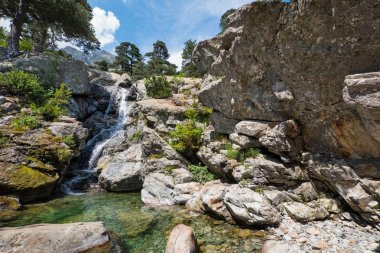Cascade des Anglais waterfall and crystal clear pool on the GR20 trail near Vizzavona in Corsica, France.  clipart