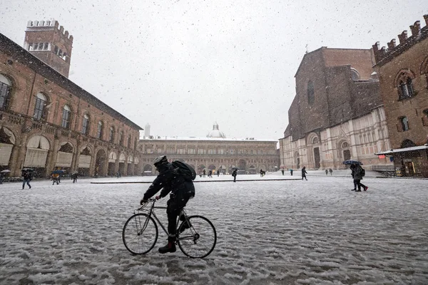 人骑自行车在马焦雷广场雪下 博洛尼亚 意大利 — 图库照片