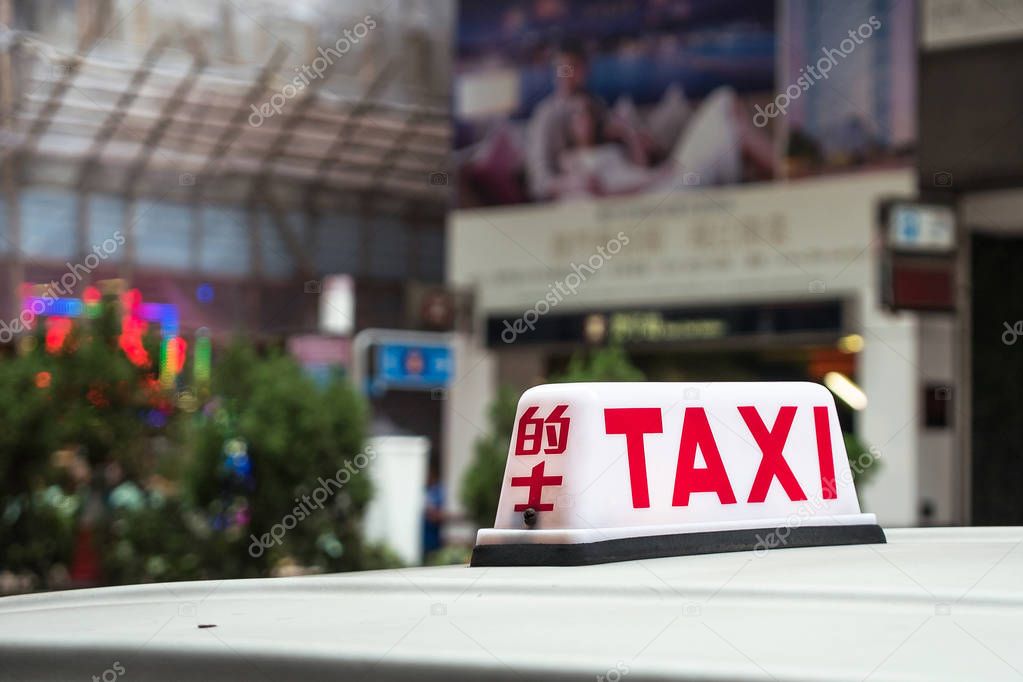 Urban Red Taxi close up sign. The red taxis have the highest fares among all, and serve all areas of New Territories, Kowloon and Hong Kong Island.