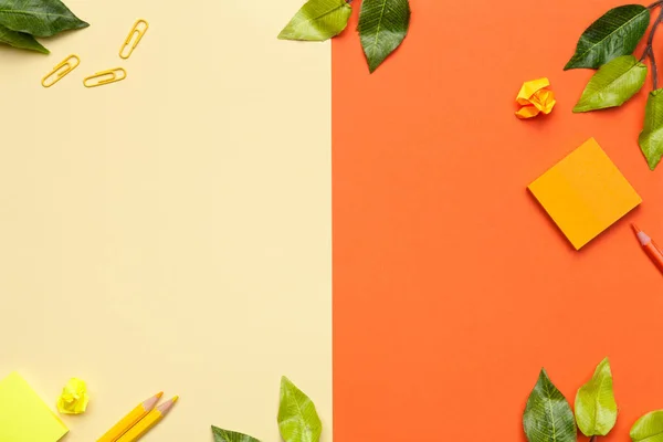 Accessoires de bureau avec feuilles sur fond jaune et orange — Photo