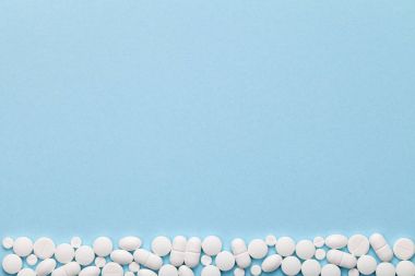 Mavi arka planda beyaz tıbbi haplar 