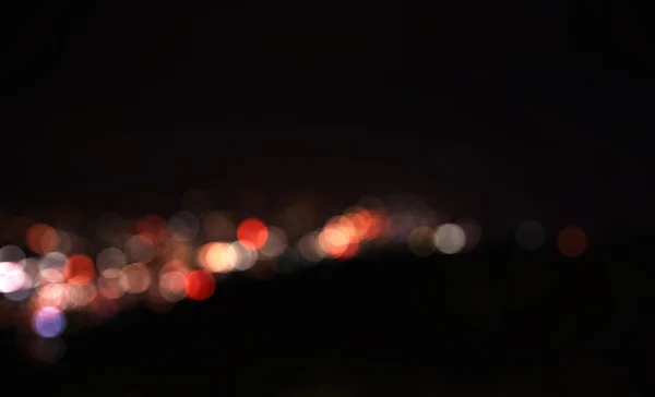 Bulanık gece arkaplanındaki renkli odaklanmış bokeh ışıkları — Stok fotoğraf