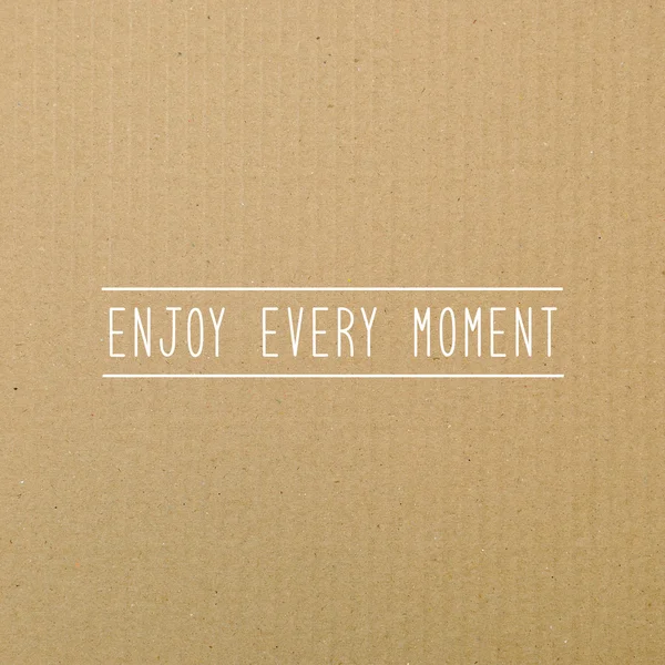 Enjoy every moment on brown paper. — Stock Photo, Image