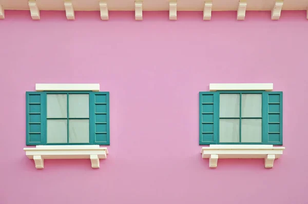 Green wooden windows on pink wall — Stock Photo, Image
