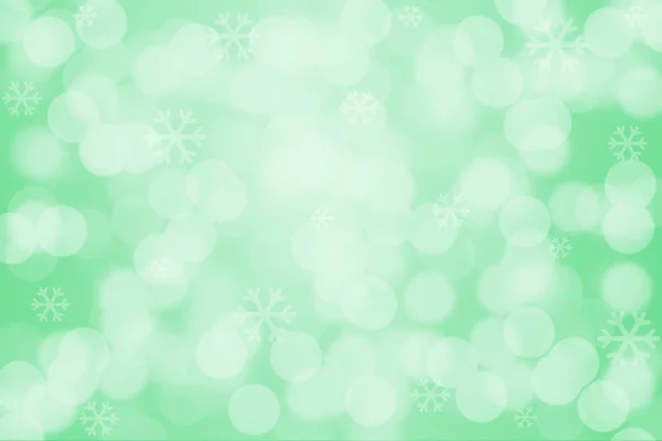 Snowflakes and bokeh light on green background — Stock Photo, Image