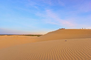 Beyaz kum tepeleri üzerinde tanımlanamayan turist