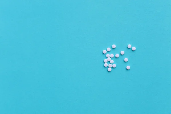 White medicine pills on blue background — Stock Photo, Image