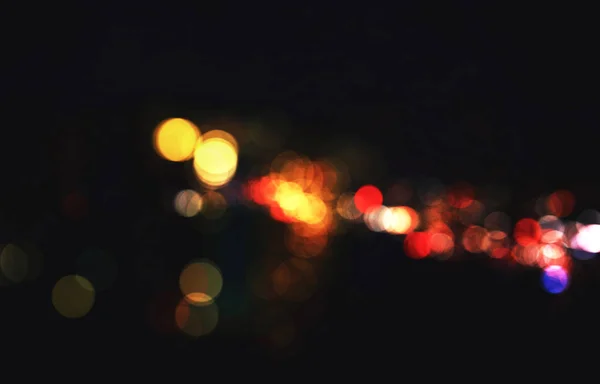 Bulanık gece arkaplanındaki renkli odaklanmış bokeh ışıkları — Stok fotoğraf