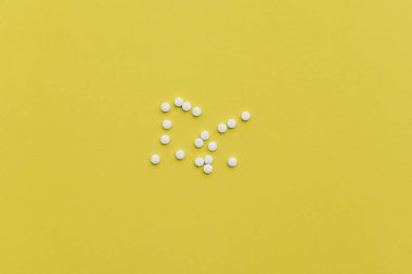 Sarı zemin üzerine beyaz tıp hapları