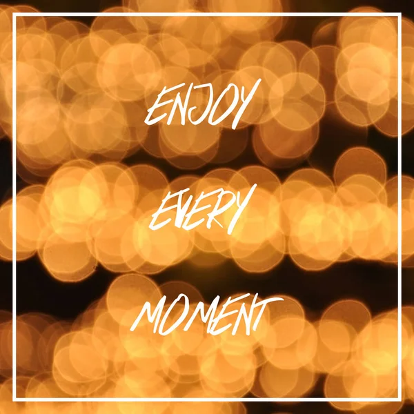 Enjoy every moment text on bokeh lights background — Stock Photo, Image