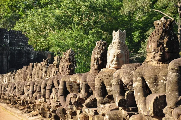 Row of sculptures in the South Gate of Angkor Thom — Stock Photo, Image