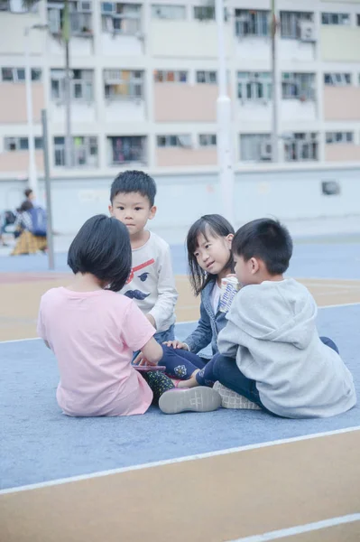 Dzieci siedząc na boisko do koszykówki — Zdjęcie stockowe