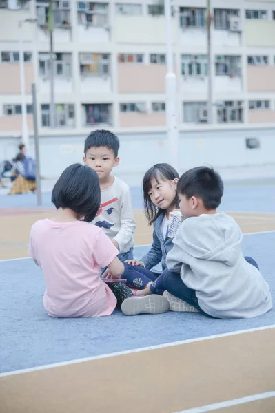 Niños sentados en cancha de baloncesto —  Fotos de Stock