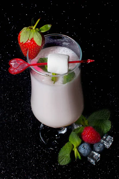 A glass of cool drink. fruit mix lemon strawberry raspberry. Berry milk soft drink.