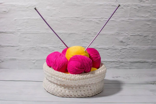 a ball of woolen thread in a white basket. Knitting and needlework.