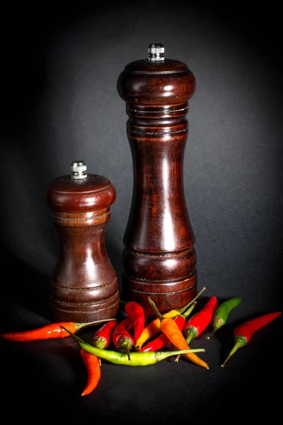 Ground black pepper in a salt shaker. Red chili pepper.