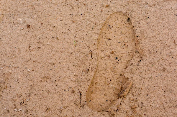 Huella de zapatos en textura de arena húmeda. Vista desde arriba. El concepto es el comienzo de un camino, un viaje, un paso hacia algo . — Foto de Stock