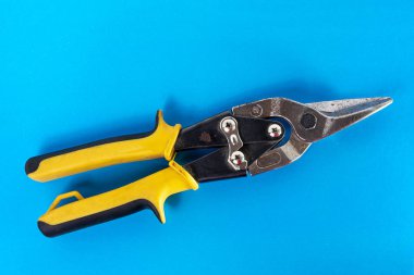 Metal için makas. Mavi arkaplanda metal levha kesme aracı.