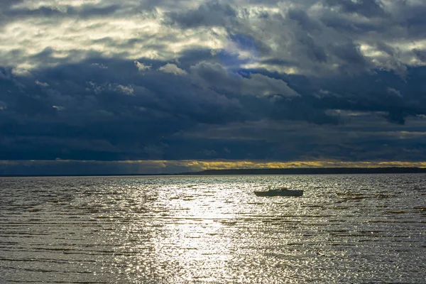 Boat on the river and dark clouds in the sky. Soft focus. — Stock Photo, Image