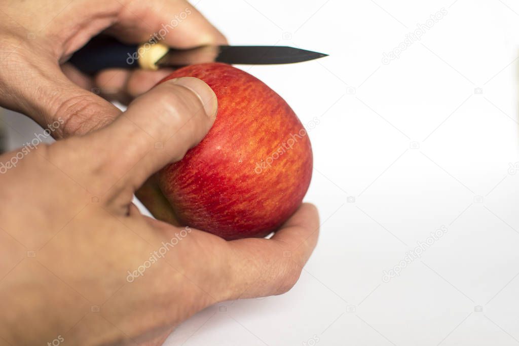 Man cleans, cuts red apple