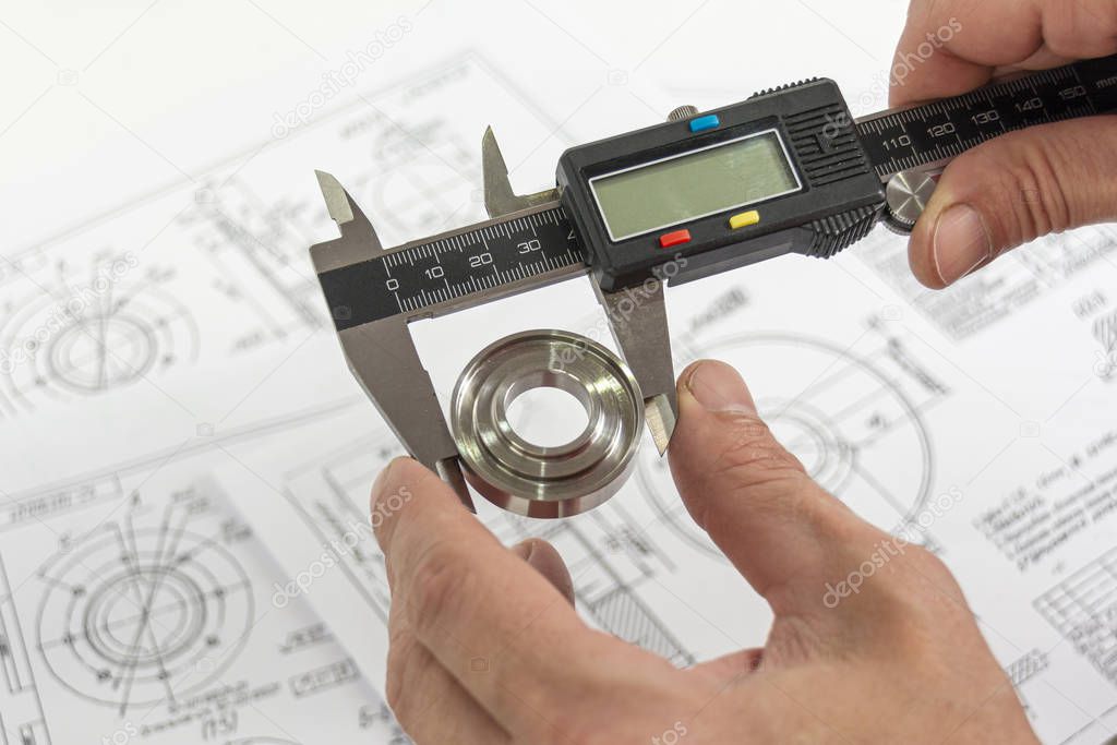 Measurement of a turned part. Electronic caliper in the technici