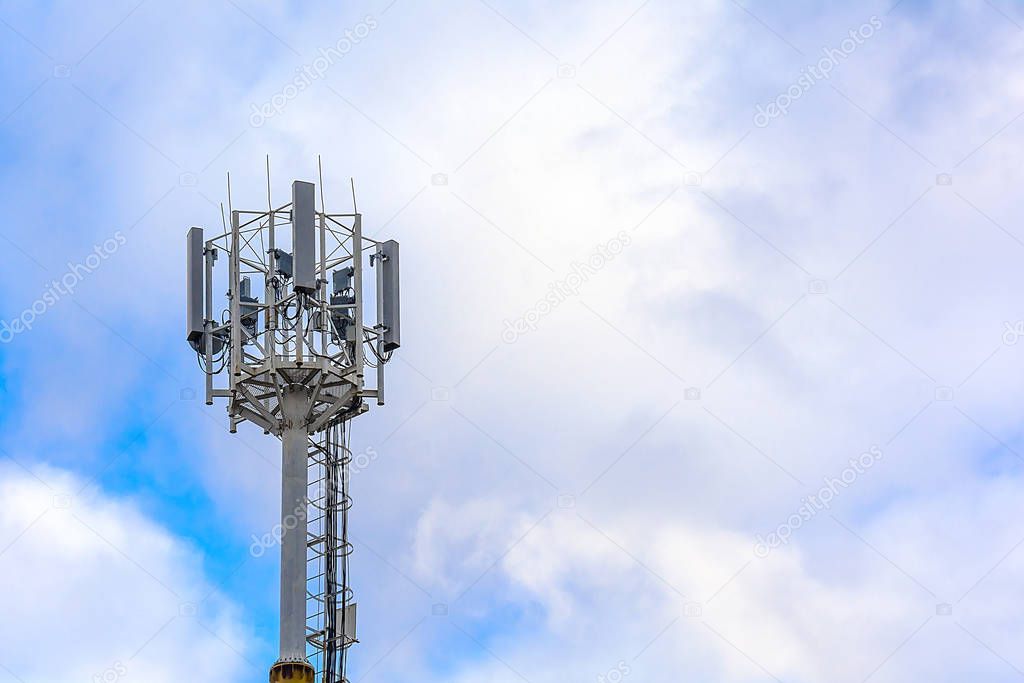 Cellular communication tower on a background of cloudy sky. Soft