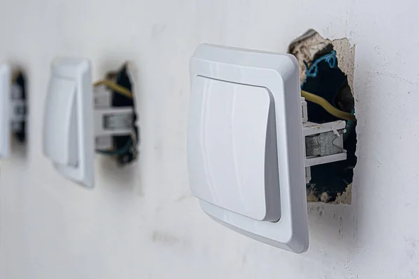 Instalación profesional de cables eléctricos e interruptores. Conexión de luces en un apartamento u oficina. Los interruptores eléctricos están listos para el montaje en pared. Reparación de cableado eléctrico y equipos . — Foto de Stock
