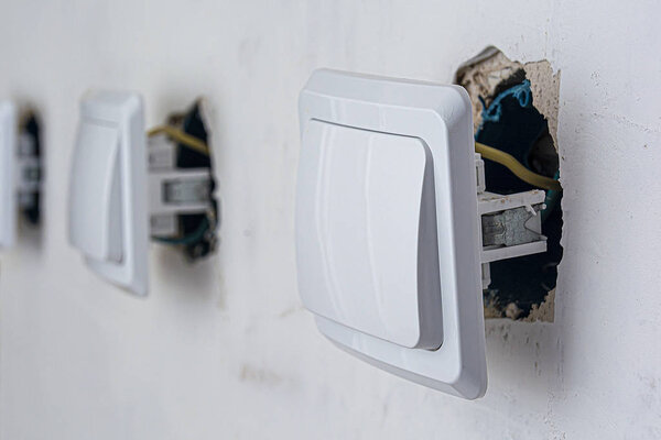 Professional installation of electrical wires and switches. Connecting lights in an apartment or office. Electrical switches are ready for wall mounting. Repair electrical wiring and equipment.