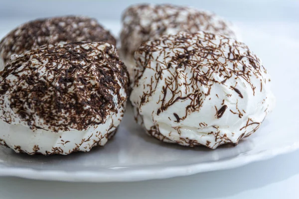 Marshmallows con cioccolato su un piatto bianco primo piano . — Foto Stock